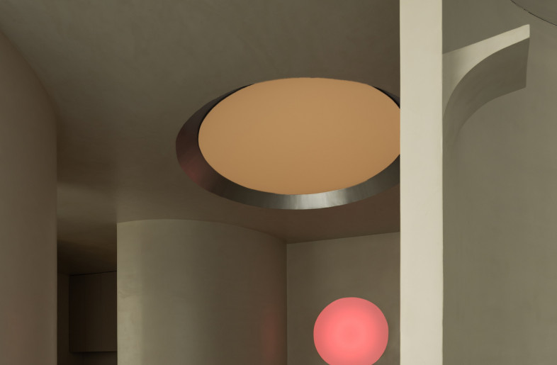Curved soft grey concrete walls surround the reception area. - Courtesy of Godot Design