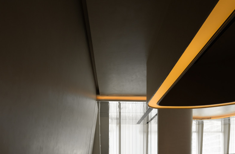 Mirrored stainless steel ceilings in the waiting area and main passageway gives the illusion of height in the low space. - Courtesy of Godot Design