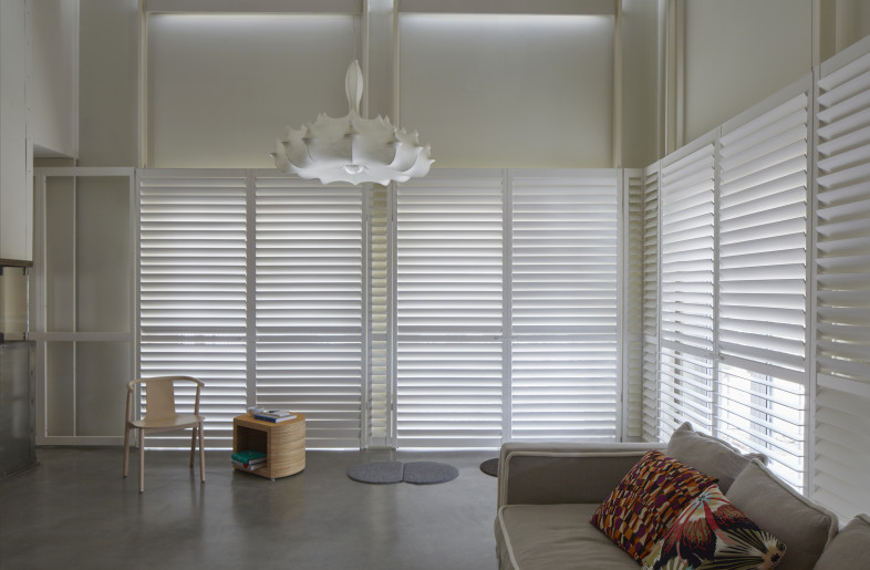 Louvers filtering light in living room. - James Brittain Photography