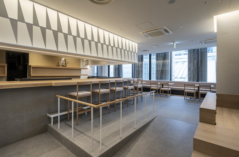 A view from the entrance includes the counter seating area and the dining area spreading behind it. - Keishiro Yamada