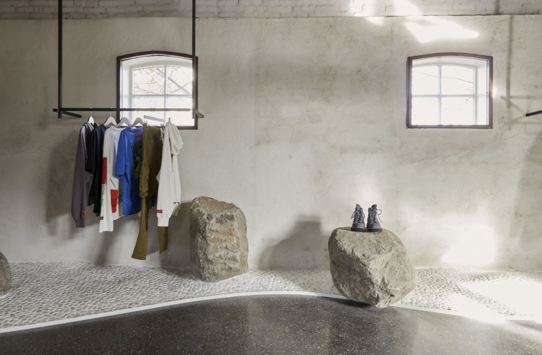 Rocks come to form in jagged whitewashed boulders that double as retail displays, polished concrete flooring, stark gray gravel, and elevated white pebble islands to house collections. - Sarah Wijzenbeek