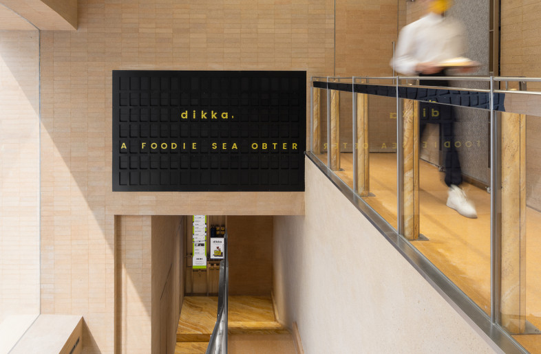 Voids were cut out of an internal wall facing a shopping area on its first floor and replaced with glass, introducing natural light into the space. - SFAP