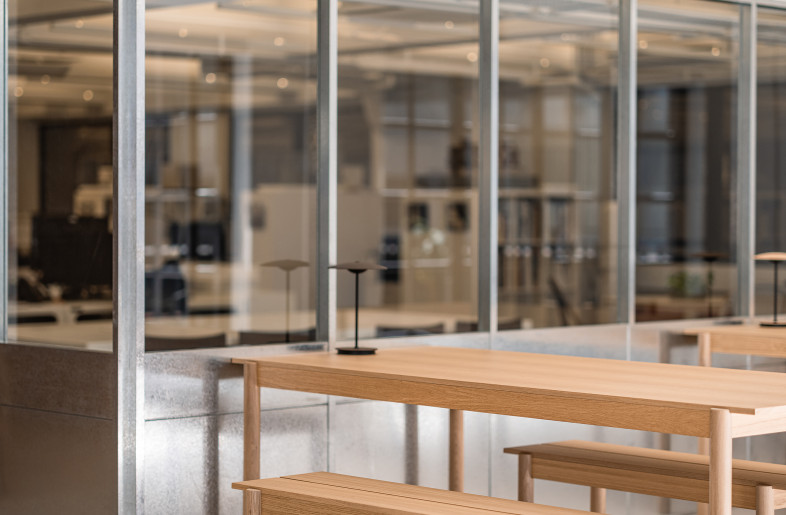 The main workspace is arranged on the lower floor, framed by galvanized steel partitions. - Kenneth Chao