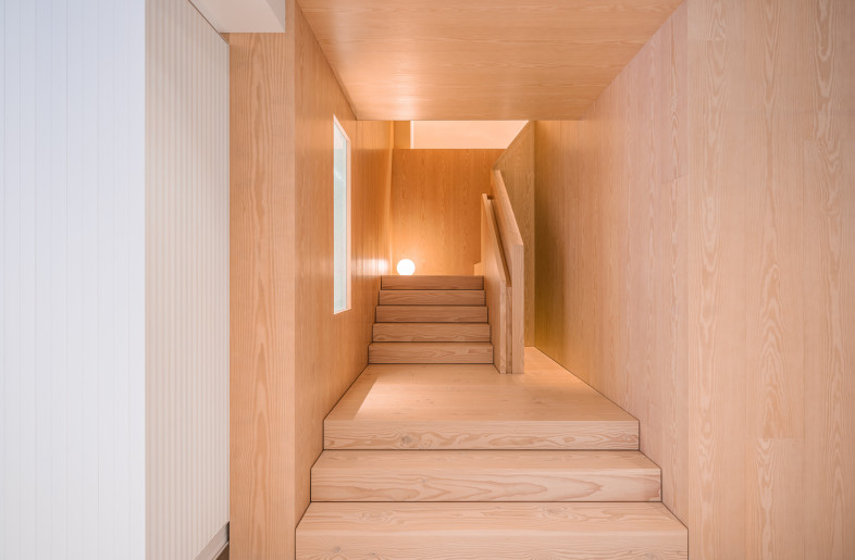 The staircase, lined with Scandinavian timber, connects the two studio floors. - Kenneth Chao