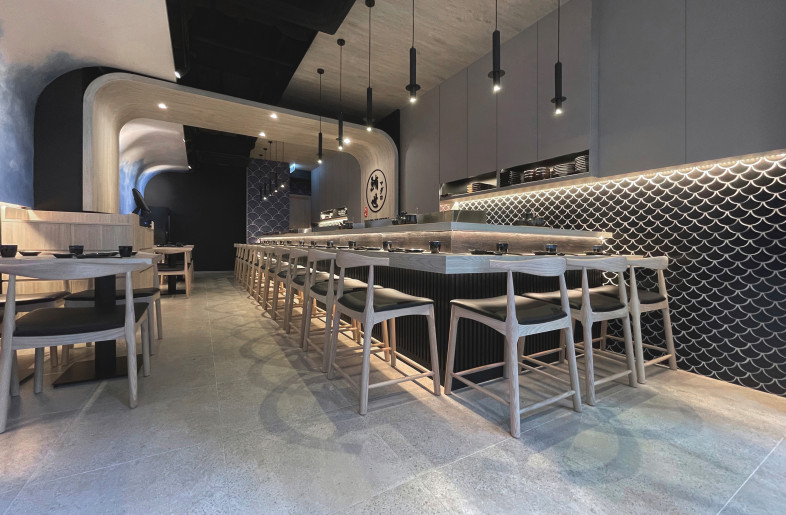 It is the black fish scale tiles on the wall and the black wood stripes on the bar that complement each other and add to the restaurant's style. In the arrangement of fish scale tiles, we see the fish moving upward, symbolizing the restaurant's business growing and becoming more distinctive. - Frank Lo