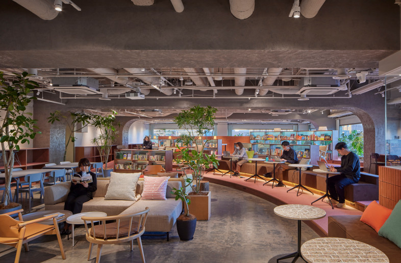 Communication library. A space that can be used freely both inside and outside the company. Normally used as a workspace, it is also rented out for seminars and exhibitions during events. The view of the library from the flat area creates a sense of unity throughout the space. - FUMITO SUZUKI