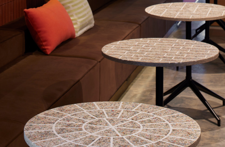 The tops of the mini-tables in the lounge are made of crushed and compressed magazines and used paper, and we engrave the patterns from the building facade. - FUMITO SUZUKI