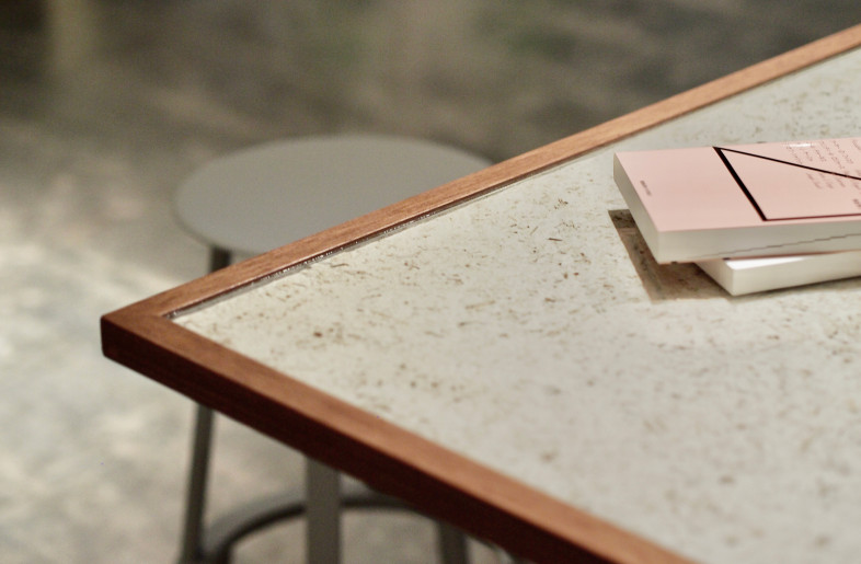The large center table in the cafe has dried leaves mixed in, which we collected from the building's square. By incorporating furniture made from these eco-friendly materials into the space, we have created a comfortable space that is in harmony with nature. - KOKUYO