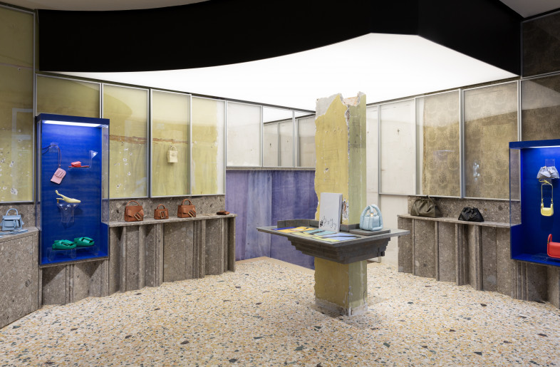 a view of BOYY's Milan flagship, including the glass  showcases with the old walls as backdrops - BOYY