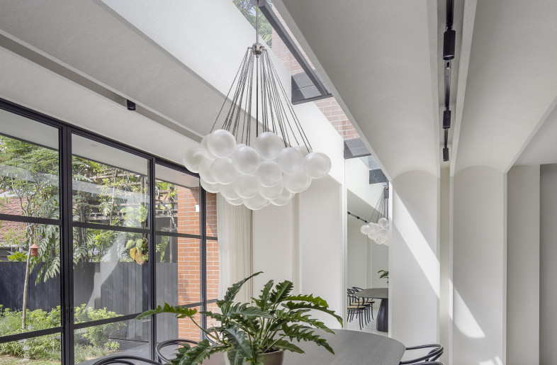 Dining Room — featuring concave wall elements moulded in textured plaster that extend into the ceiling in the form of linear arches, inspired by the existing curved interiors. - Triston Yeo