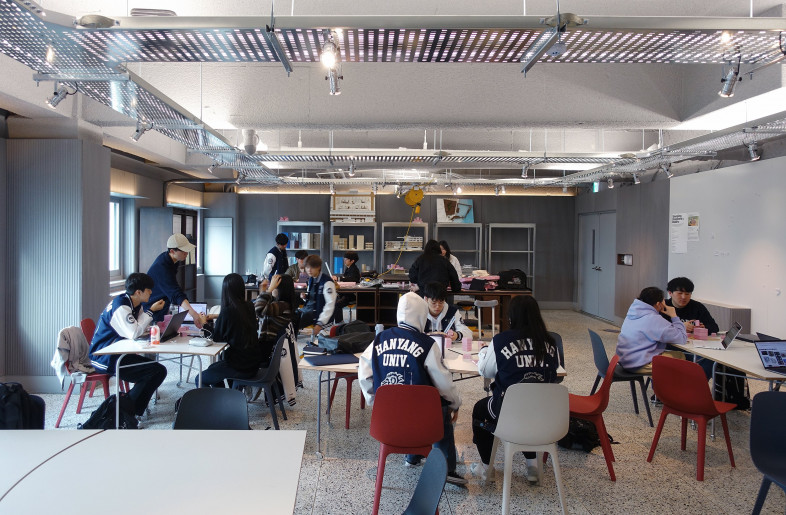 Students utilize the studio space for brainstorming, collaboration, and hands-on making seamlessly. They gather around the learning tables, discussing ideas, sketching designs, and prototyping their proposal. - ChangyeobLee
