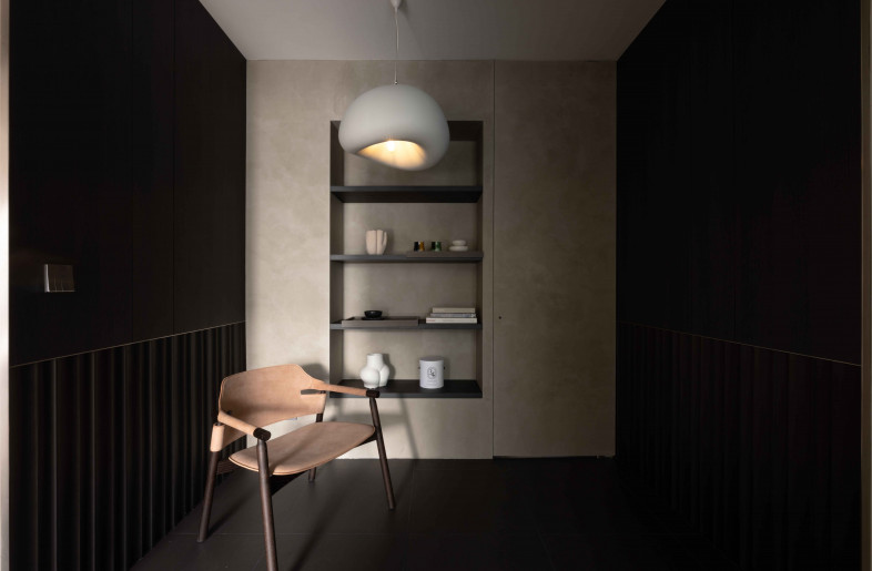 Needing a private corner for his alone time and travel collection, the corridor leading to the lounge area is set out to give a distinct contrasting mood.. Beyond the grey textured display wall lies a concealed door that leads to a room for his helper. This dual-purpose utilisation of space not only maximises the functionality but also enhances the versatility of the area. - Ng Ci En