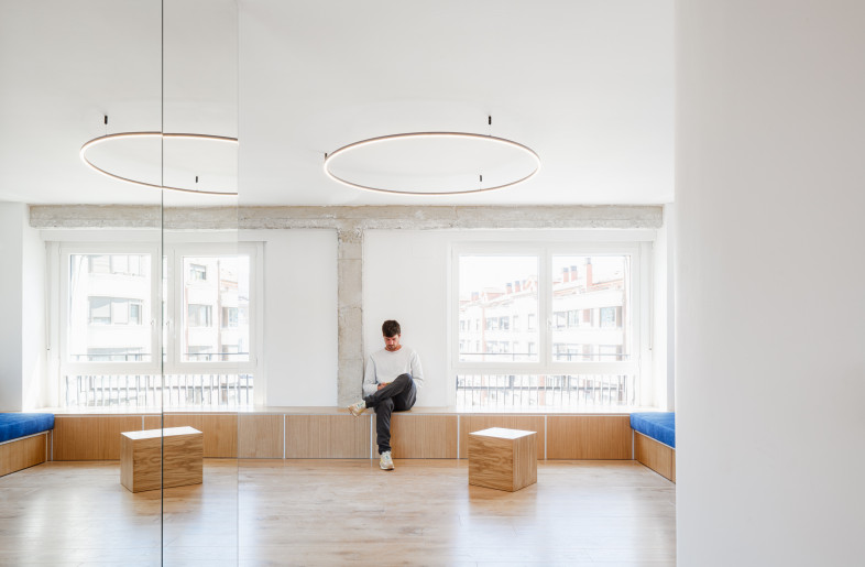 The custom shelving unit is flexible, comprised of box like components that can be moved and serve as seating, but also integrates a bespoke sofa and a window seat. - Aitor Estevez