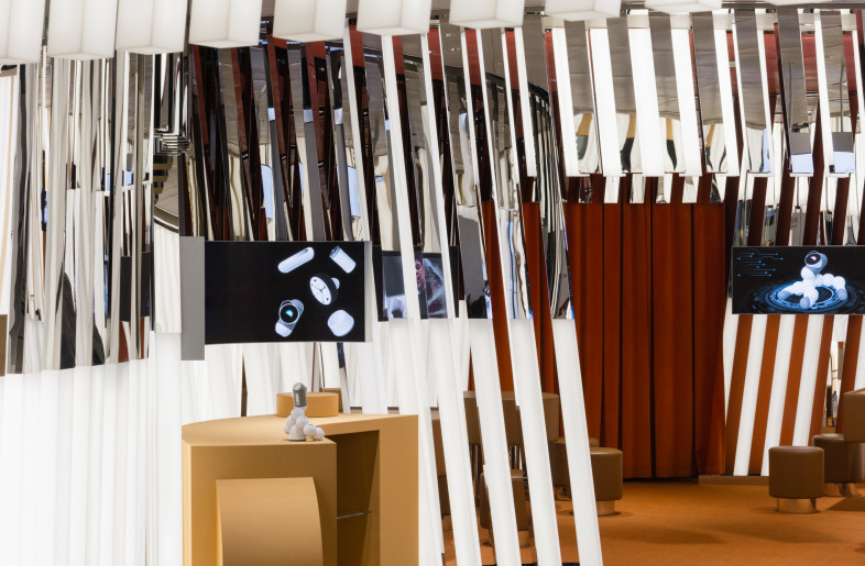 Workshops take place in the back of the space, where LED screens playfully depict animated robot characters. - Wen Studio