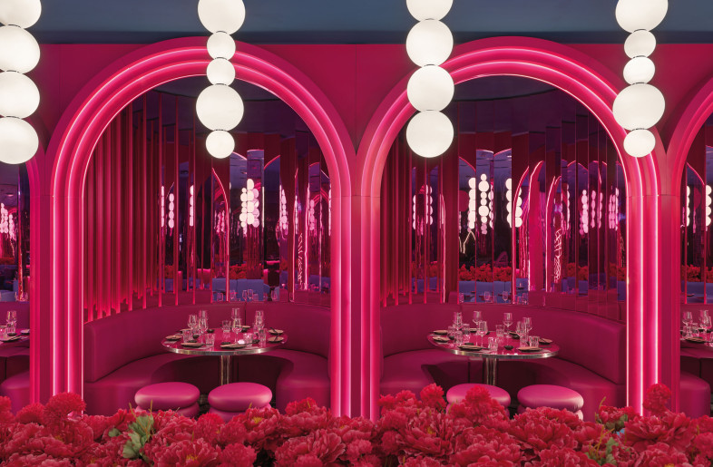 The space culminates in a backdrop of tapered arches in relief, emphasized by lines of light that enclose semicircular niches dressed with mirrors, sofas and tables in total magenta. - Matteo Piazza