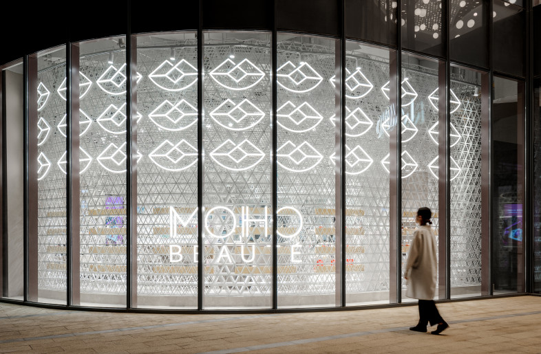Entrance Facade 　The fine grids expressing the theme of “the smooth skin texture” is embracing the facade and gently connecting the inside and outside of the store. - Shanghai Sizhu Photography Ltd.