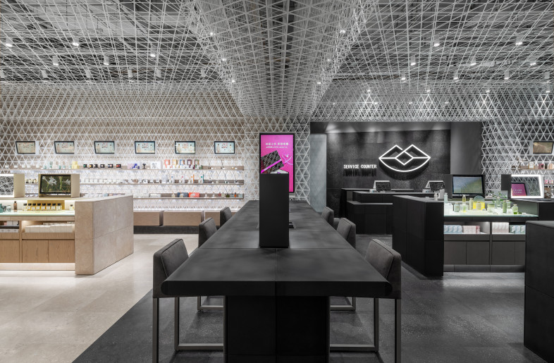 Perfume Area & Skincare Area　 Within a unified environment surrounded by a grid pattern, the perfume area and skincare products area are expressed by different stone materials of the floor and fixtures. - Shanghai Sizhu Photography Ltd.