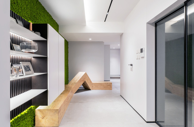 Entering the foyer, besides the moss cladded wall, the first thing that catches attention is a wooden art installation, it served not only as an art piece that decorated the long corridor, but also a shoes changing seat, which combined artistic and functional elements into the interior design. - Millimeter Interior Design Limited