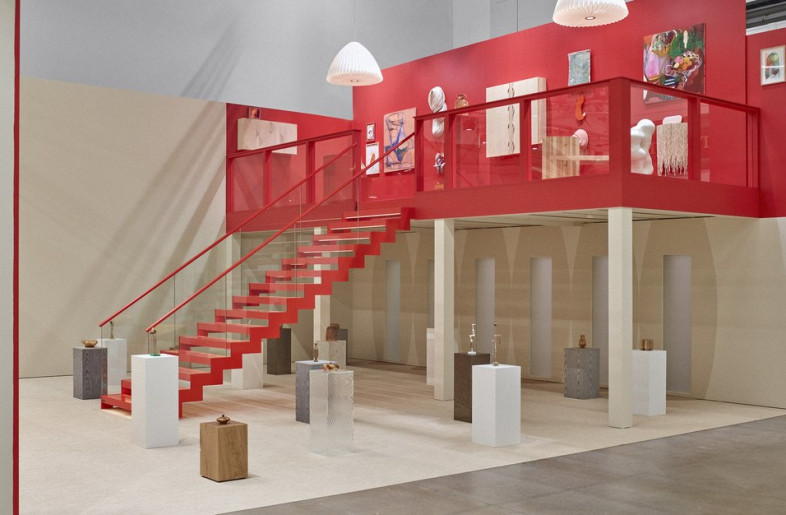 Coloured in light neutral tones and bright red accents, the exhibition space was organized in different sections, each showcasing products and providing visitors with a space for respite from the bustling environment. - Katri Kapanen