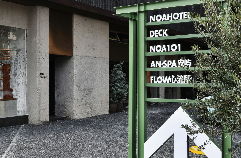 The entrance quietly blends together in matt grey and dark black; grey-green I-beam girders bore with directional markings turn, twist and extend to showcase the spatial movement. - Xiaodong Xu