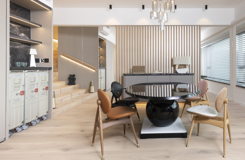 The property was completely demolished, leaving bare shells. A new staircase was built to connect with the upper entity. The stairway was highlighted with a modern pendant light, a sculptural wooden banister, and floor-to-ceiling mirrors to create a bright and spacious ambiance. - Clifton Leung Design Workshop