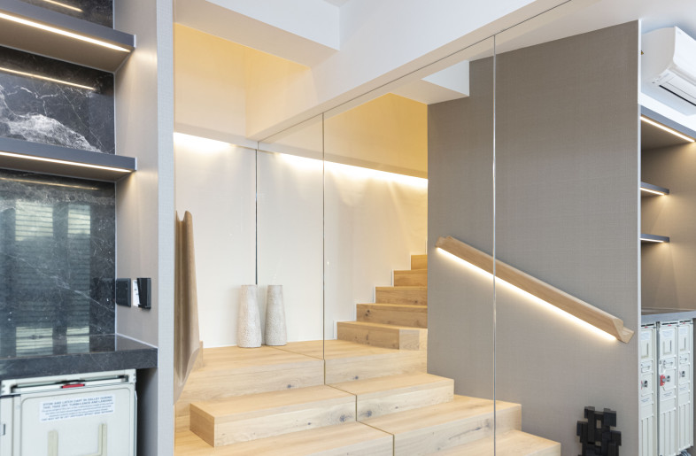 A new staircase was built to connect with the upper entity. The stairway was highlighted with a modern pendant light, a sculptural wooden banister, and floor-to-ceiling mirrors to create a bright and spacious ambiance. - Clifton Leung Design Workshop