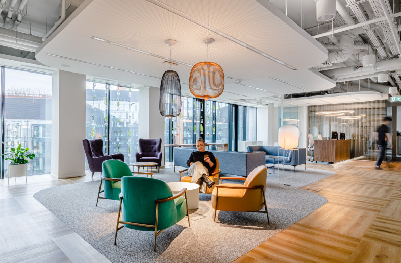 The office's focal point is its welcoming entrance area, which is designed with versatile furniture to serve multiple purposes: as a traditional reception area and a casual meeting spot for staff. - Adam Grzesik