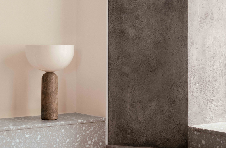 A terrazzo plinth envelopes the living room . The meeting of terrazzo step and plaster portal creates a raw architectural moment. - Common Studio