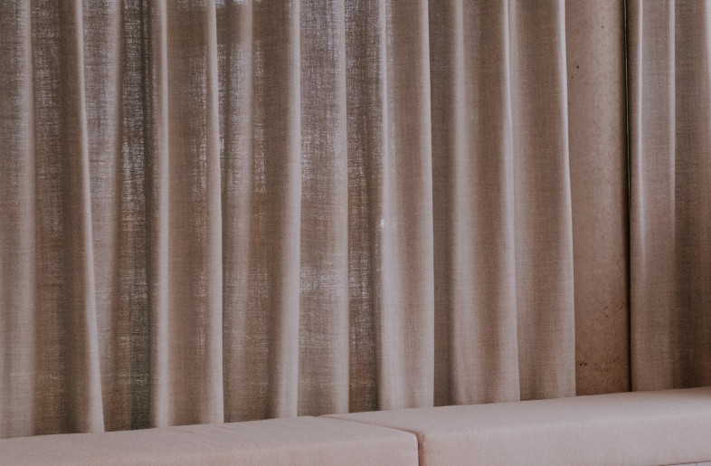 In the meeting room, the combination of Belgian linen, bouclé fabrics and warm wood softens the presence of the exposed concrete beams. Meanwhile, the application of aluminium HPL is a nod to the industrial setting’s existing windows. - FLORE DE WACHTER