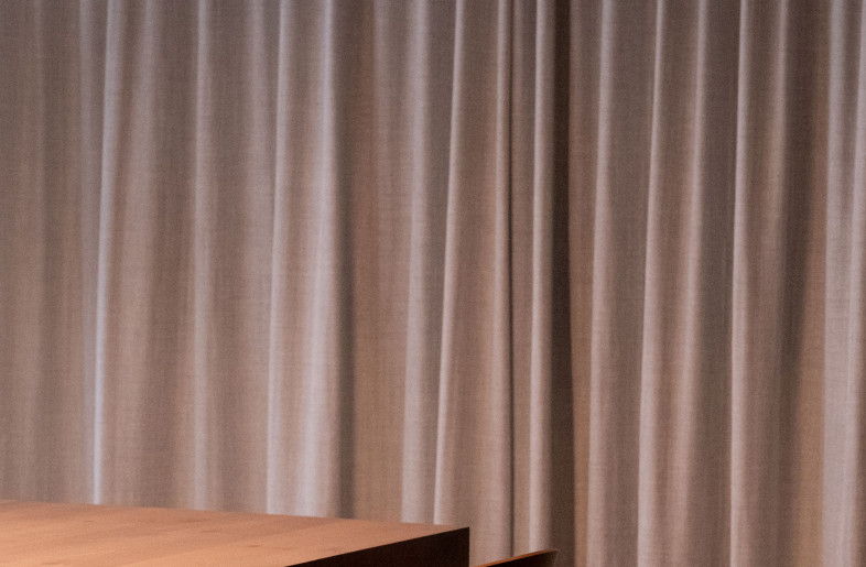 In the meeting room, the combination of Belgian linen, bouclé fabrics and warm wood softens the presence of the exposed concrete beams. Meanwhile, the application of aluminium HPL is a nod to the industrial setting’s existing windows. - FLORE DE WACHTER