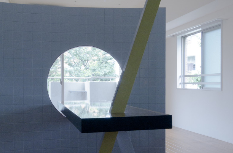 The curved surface softly separates the living room and kitchen. - Yuki Konko