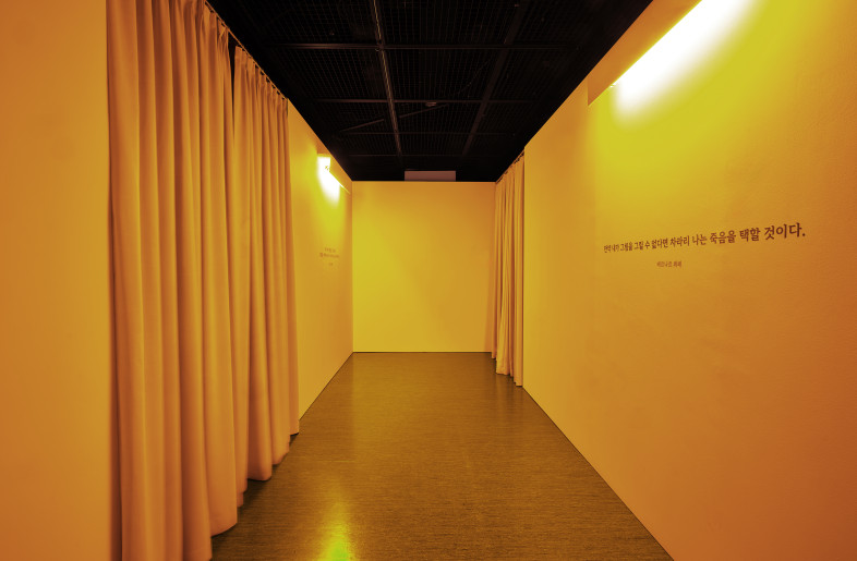 Before encountering the works on the theme of 'death,' the transitional space is designed to express his psychological state of despair over his inability to paint due to Parkinson's disease. For him, the act of painting was akin to breathing, and not being able to paint likely felt like being trapped in a colorless, suffocating space. Thus, monochromatic lighting is used to create an atmosphere of death, where both color and air seem to have vanished. - Munch studio