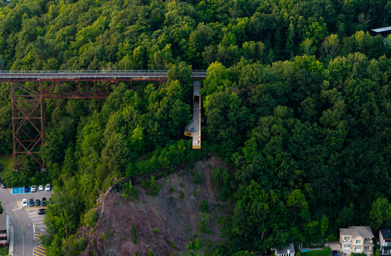 The highlight of the project is a striking pedestrian bridge, positioned perpendicular to the railway viaduct, extending over the archaeological remains, the cliffside, and above the St. Lawrence River— the very waterway that bore witness to the arrival of the first French explorers. This landmark structure offers a 360-degree perspective on history and landscape, framing breathtaking views of the river, horizon, and traces of the past. - Loïc Lefebvre