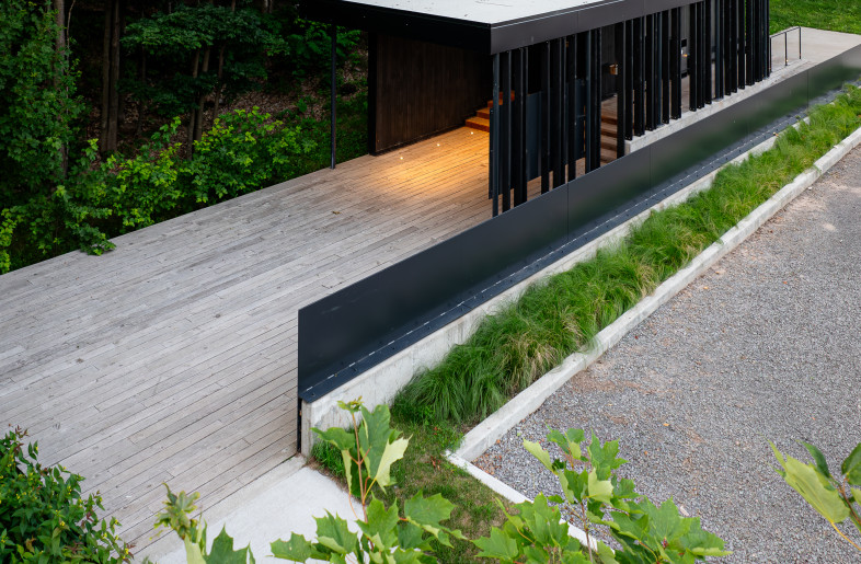 The visitor pavilion, clad in charred wood using the shou sugi ban technique, symbolically evokes the fire that once destroyed the original settlement. This understated structure blends seamlessly into the wooded topography, offering visitors a contemplative starting point. - Loïc Lefebvre