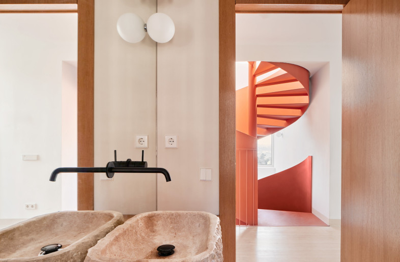 A master bedroom features a walk-in closet and en-suite bathroom with rugged stone sinks. - José Hevia