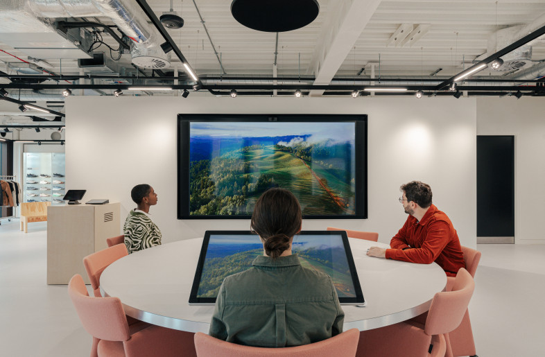 The showroom creates an interactive brand experience. A custom circular meeting table includes an integrated touchscreen and RFID reader that activates digital content when products are placed on its surface. - Chris Wharton