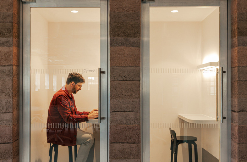 Phone booths framed by handcrafted Clayworks walls, offering privacy within a natural, tactile setting. - Chris Wharton
