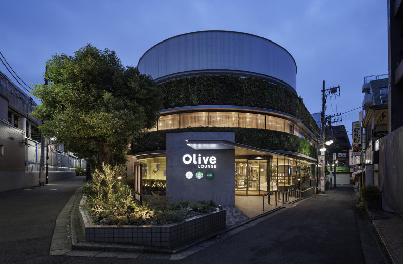 We retained the facade, the familiar face of a long-standing station-front bank, while reimagining what a bank should look like in the future. From the gaps in gray that accentuate the building’s original form, glimpses of olive green—the signature color inspired by the facility’s name, Olive LOUNGE Shimotakaido—peek through. - Nacása & Partners Inc.