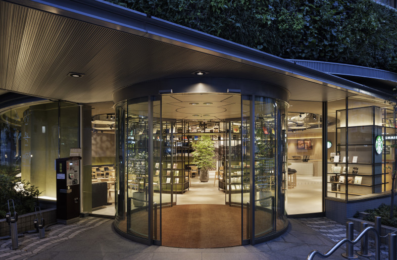 The entrance vestibule, evoking the formality typical of Japanese banks, is aligned along the central axis of a circular core, offset from the exterior wall. From within the vestibule, one can see how the spatial lines connect directly to the architectural center, revealing a strong integration between the newly constructed interior and the existing structure. - Nacása & Partners Inc.