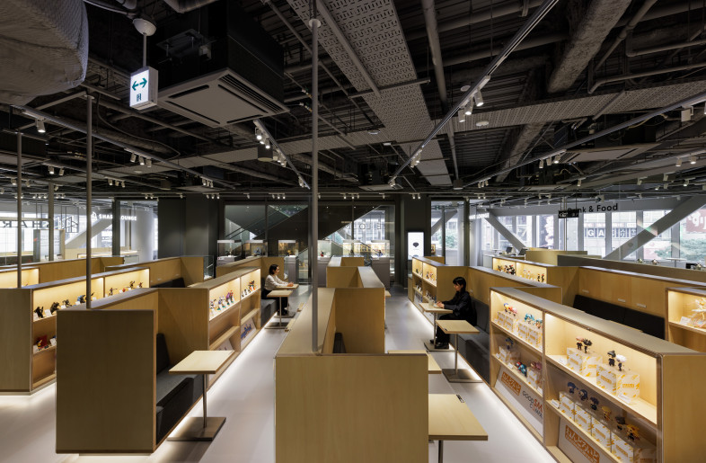 The fixture, with a height of 1350mm, is arranged in a nested configuration, with seating and display shelves integrated into the space. This layout fosters both a shared spatial awareness and a comfortable sense of enclosure. - Nacása & Partners Inc.