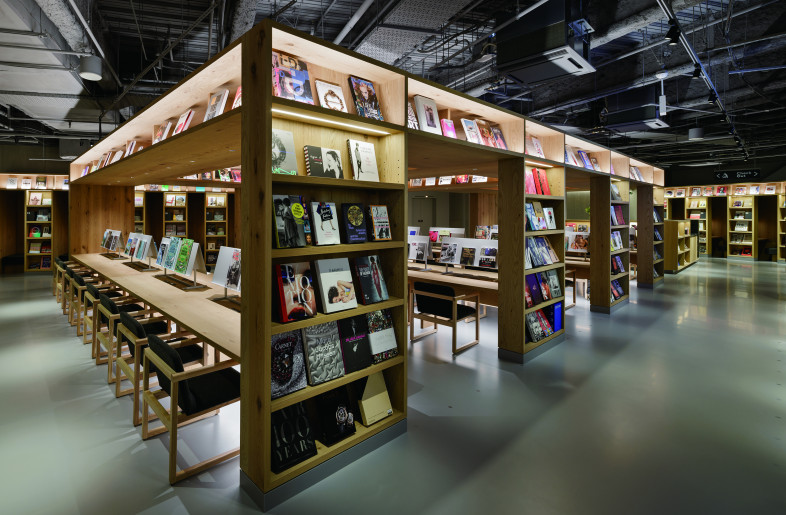 The fourth floor is designed with Shibuya's creative workers in mind. A tower-like bookshelf lined with books and a large communal table symbolize an “inspirational space”—a place where new ideas are sparked and shared. - Nacása & Partners Inc.