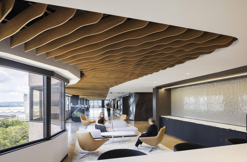 A lounge area features sweeping views and a sculptural wood-slat ceiling, adding warmth and movement as well as creating a relaxed yet sophisticated environment for informal meetings and conversation. - Evan Thomas/studiothomas