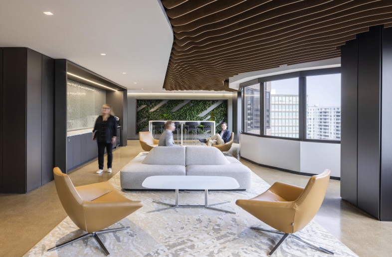 This bright corner lounge pairs comfortable seating with a green living wall and city views. It also offers an energizing space for conversation, breaks, or casual collaboration. - Evan Thomas/studiothomas