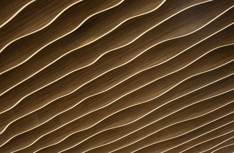 The sculptural wood ceiling reveals its flowing and wave-like rhythm -- an organic design element that brings warmth, movement, and continuity throughout the space. - Evan Thomas/studiothomas