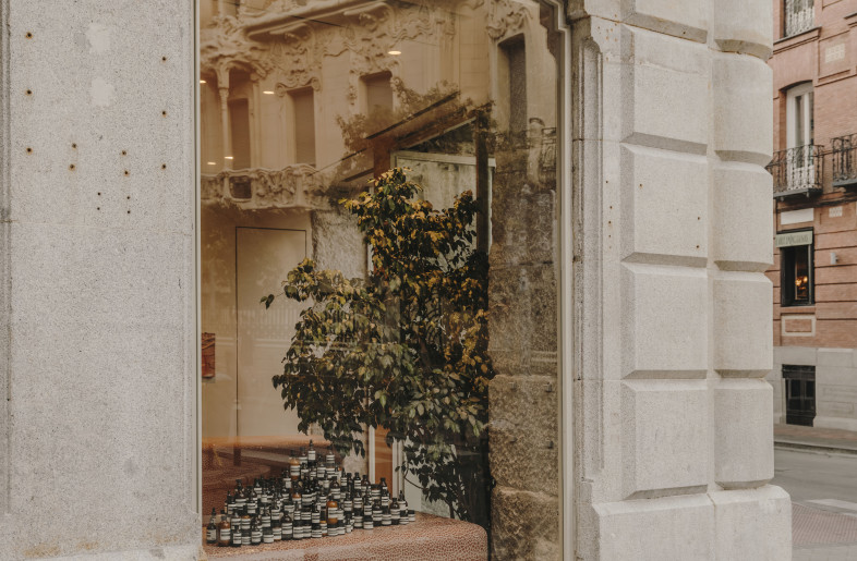 Products on display structure seen through the glass window with the Longoria Palace reflected. - Salva López