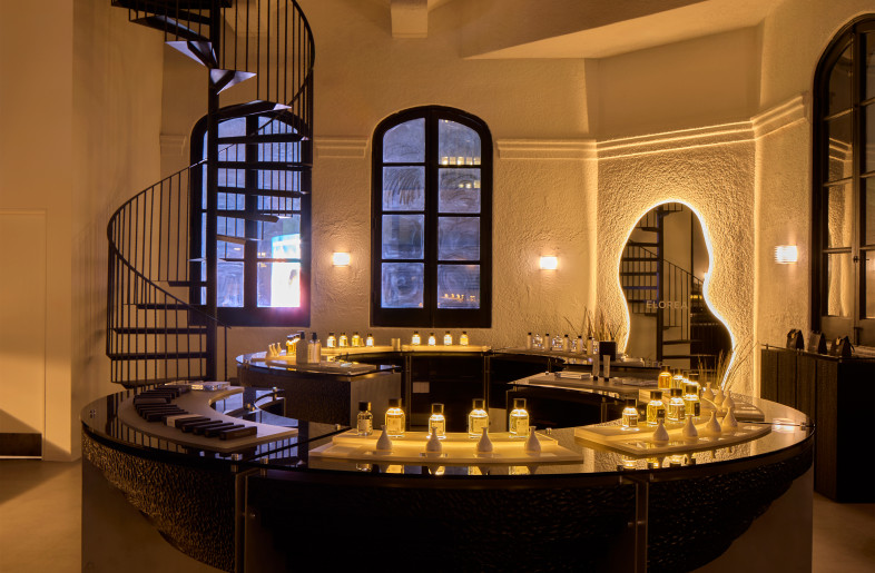 A softly lit spiral staircase and glowing perfume bottles lend the perfumery a chapel-like atmosphere after dark. - Ye Rin Mok