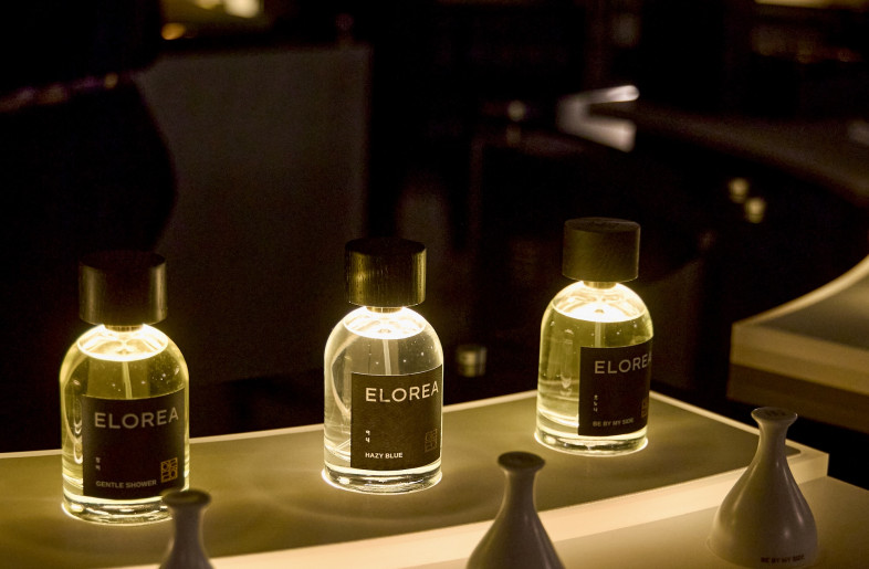 Close-up of the underlit perfume display featuring Elorea fragrances, creating a theatrical glow reminiscent of votive candles. - Ye Rin Mok