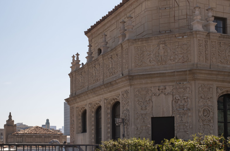 Rooftop view of the 1920s Spanish Colonial Revival building housing Elorea, with detailed architectural ornamentation and outdoor seating. - Ye Rin Mok