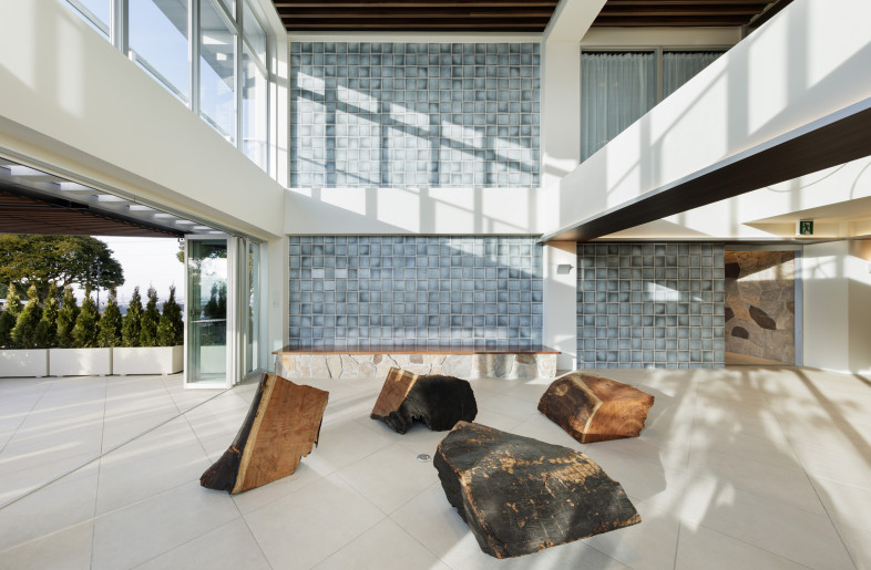 The atrium is flooded with natural light from two directions and tile walls that resemble glass blocks. - Nacasa & Partners Astushi Nakamichi