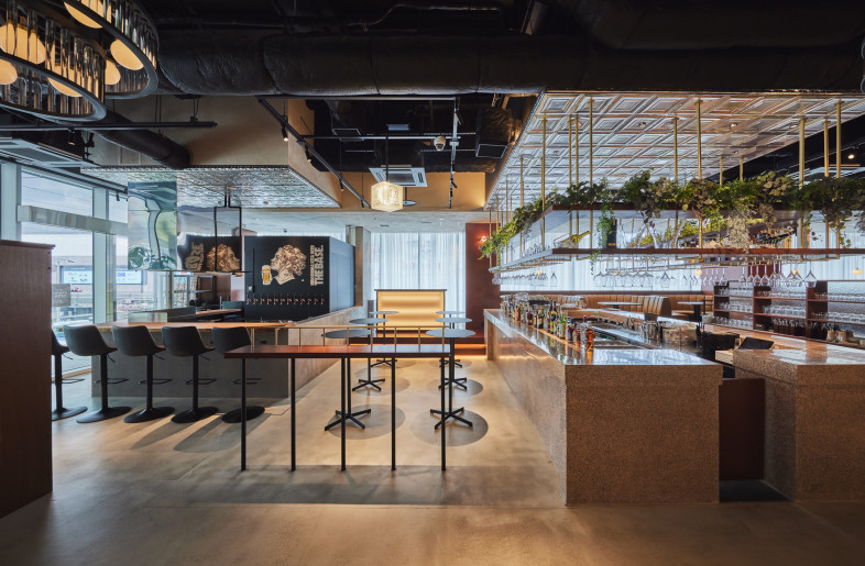 Strategically positioned, the DJ booth bridges the vibrant atmosphere of the craft beer bar on the left and the inviting ambiance of the main bar counter. - Photographer Shinsui Ohara